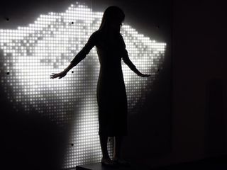 View of 'Ice Angel' by Dominic Harris and Cinimod Studio - a female figure with her arms stretched out in front of a black and white digital background with angel wings