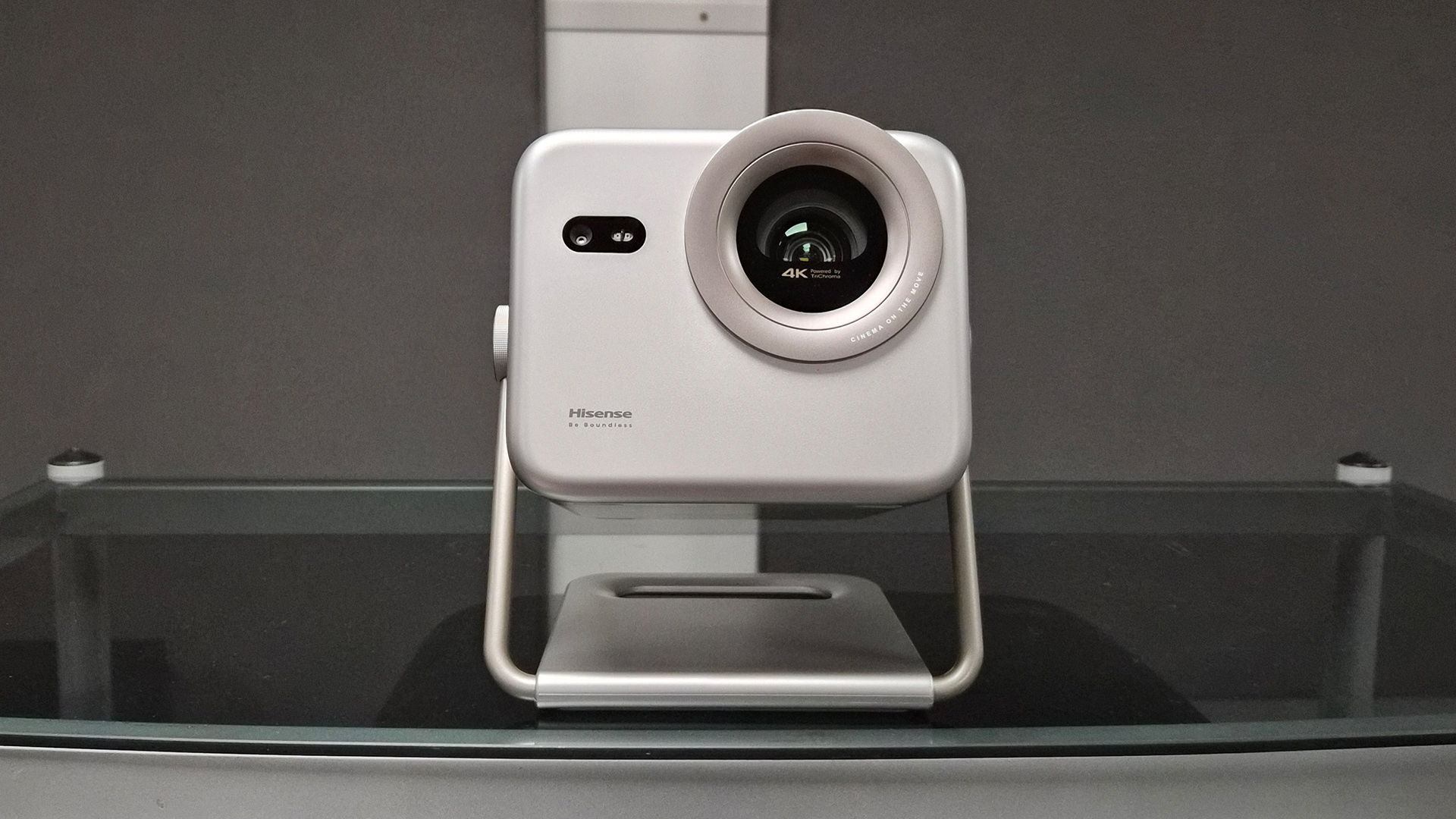 Hisense M2 Pro lifestyle projector on glass coffee table in front of grey wall