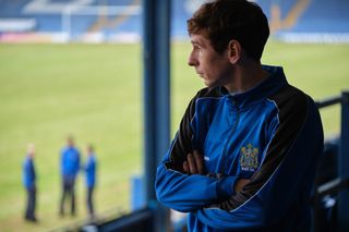 Andy Woodward (Gerard Kearns) looks on from the stands while at Bury FC.