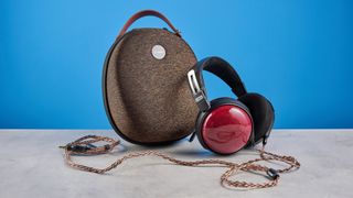 the fiio ft13 wired headphones with wood cups and copper cable photographed against a blue background