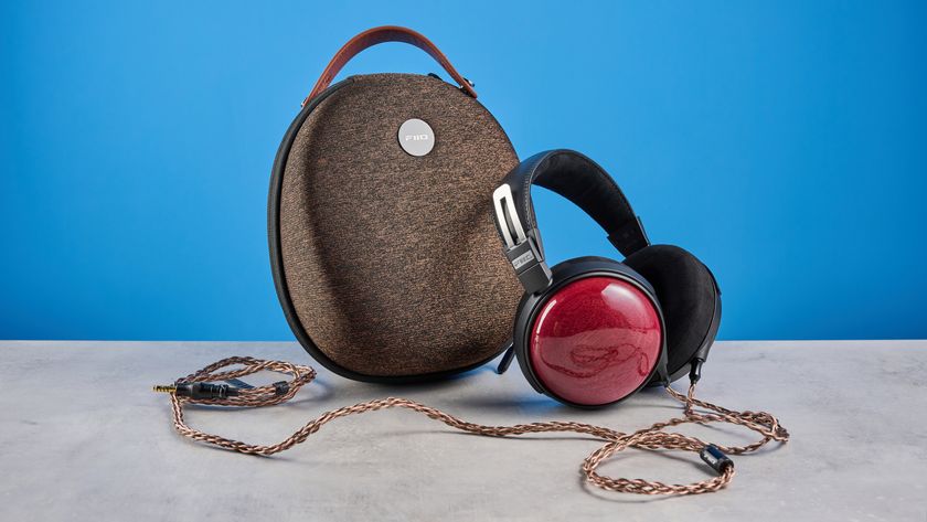 the fiio ft13 wired headphones with wood cups and copper cable photographed against a blue background