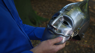 Man holds metal mask from Face of War educational packet in Age of Empires IV