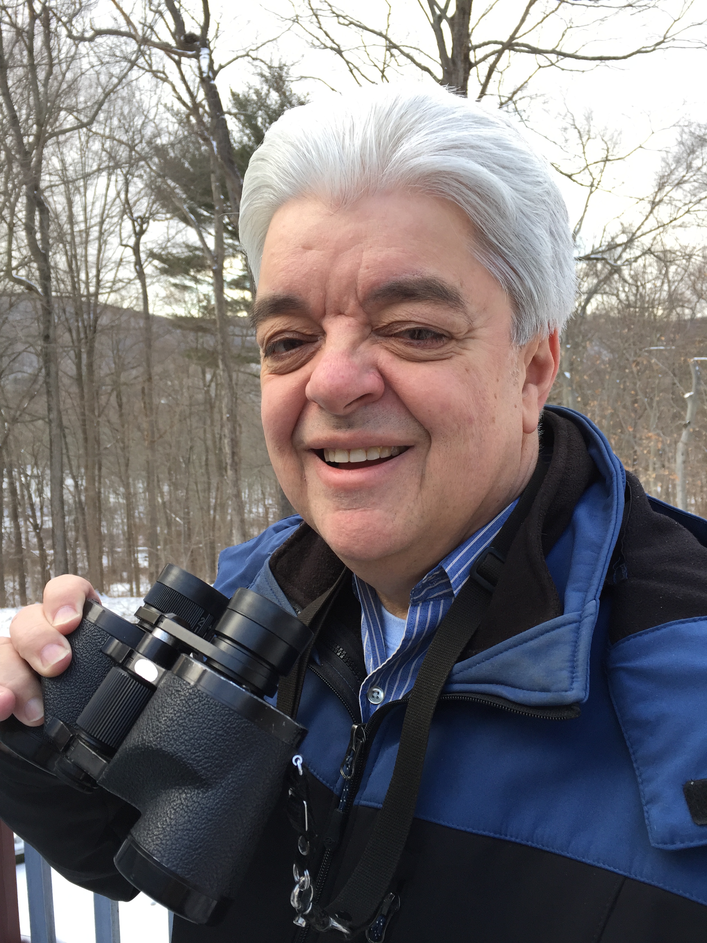 Joe Rao poses with binoculars outside.