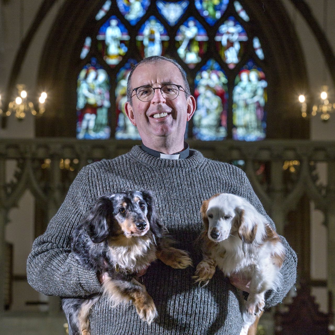 Rev Richard Coles pictured with his two dogs Pongo and Daisy at St Mary the Virgin Church in Finedon, Northamptonshire.