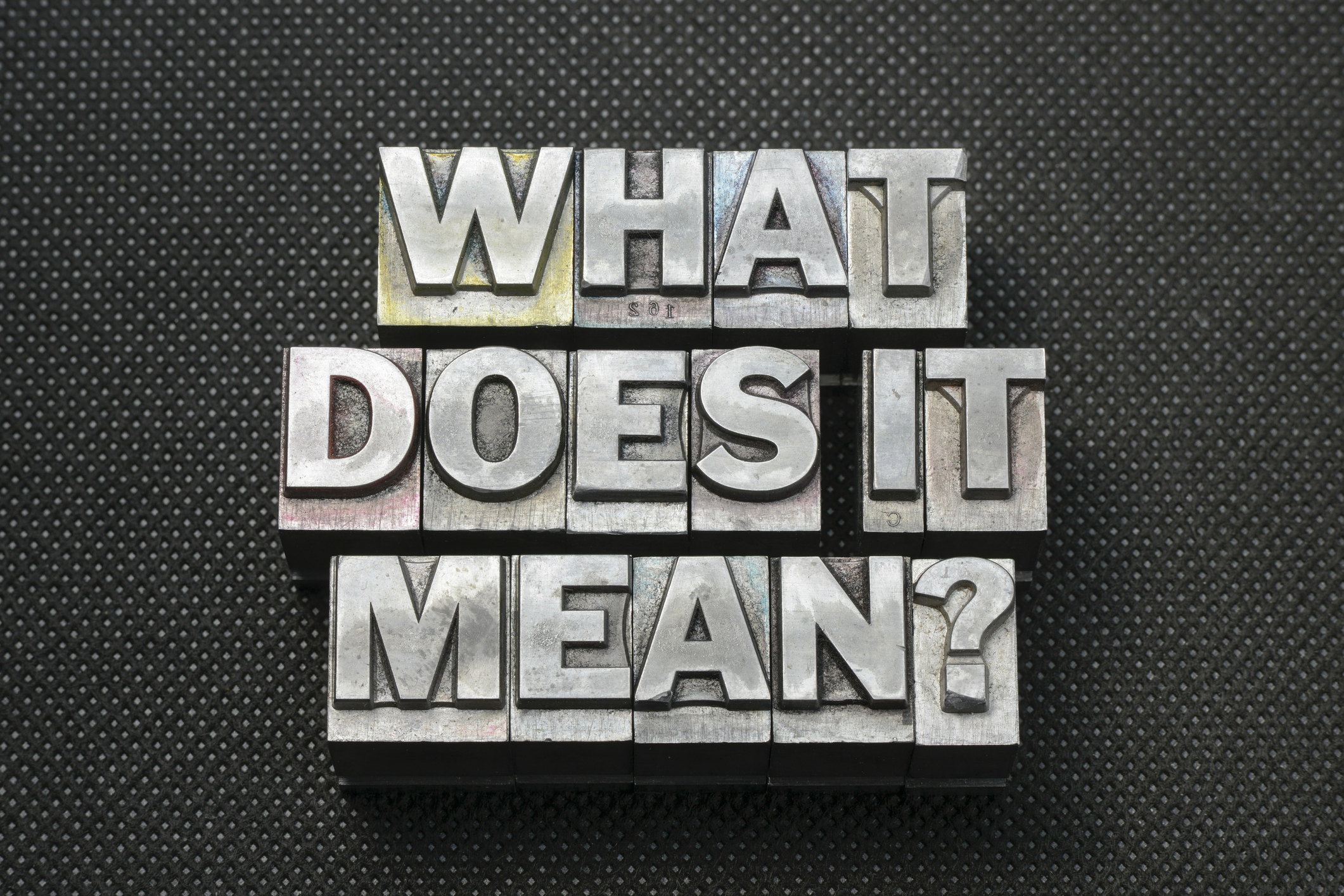 what does it mean question made from metallic letterpress blocks on black perforated surface
