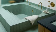 a tiled bath tub in sea foam green