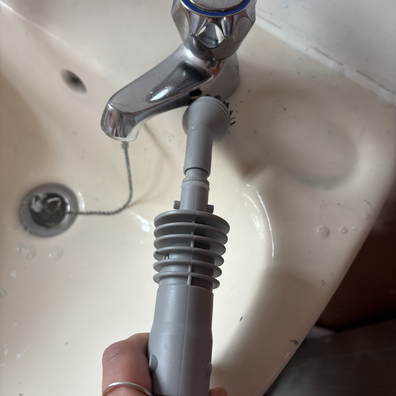 using the Beldray Digital Handheld Steam Cleaner to clean a tap