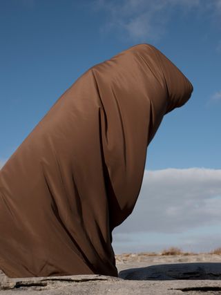 A person wrapped in brown fabric.