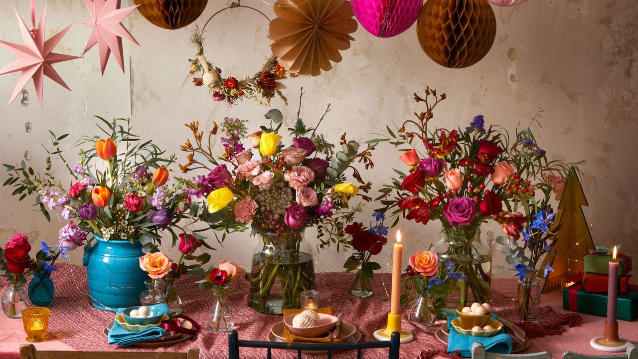 dining table with colourful flower vases and candles