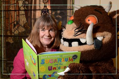 Julia Donaldson reading a book with the Gruffalo sat beside her