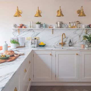 Cream shaker kitchen with marble worktops and brass knob handles