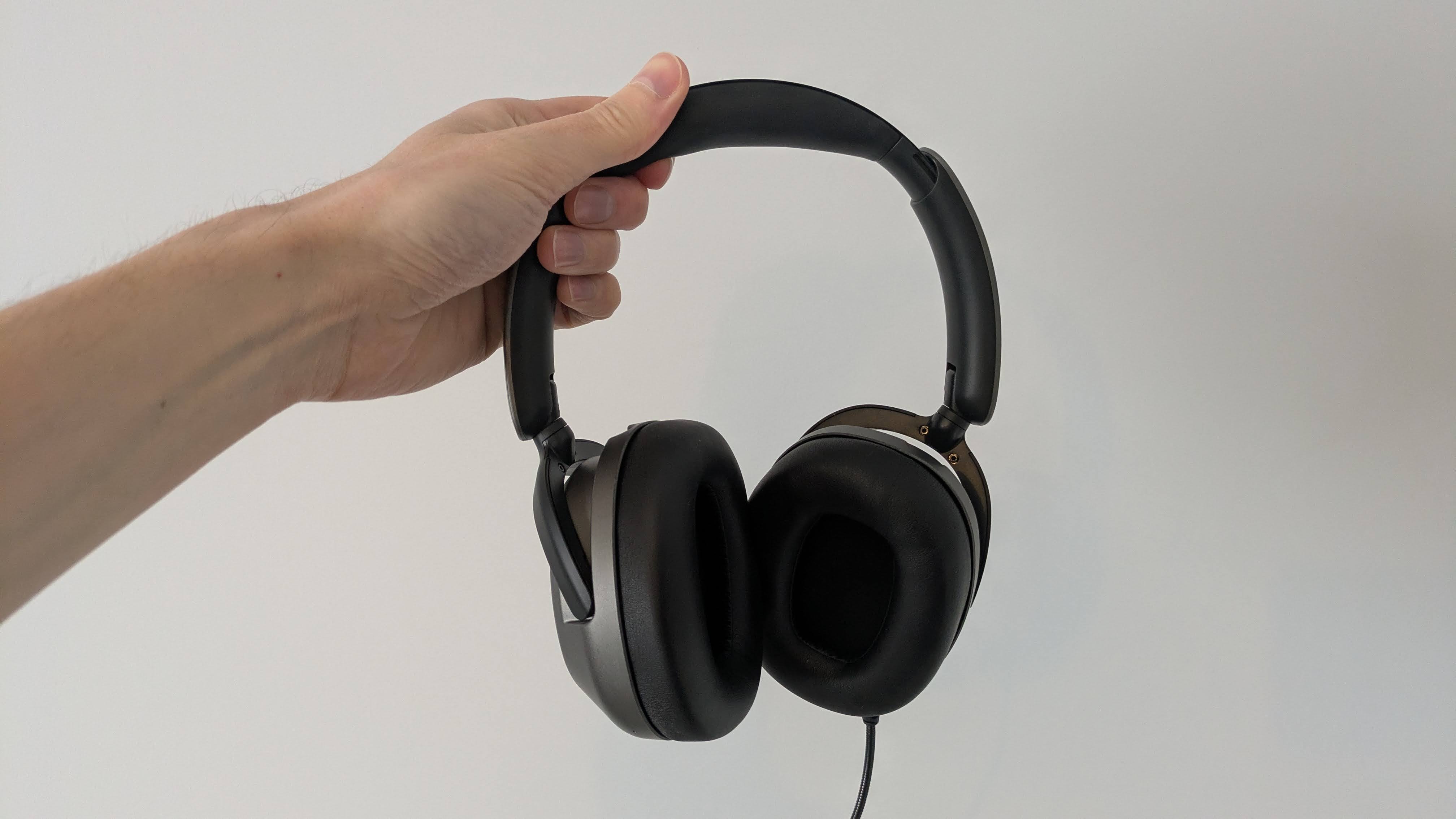 hand holding OXS Storm A2 headset against a white background