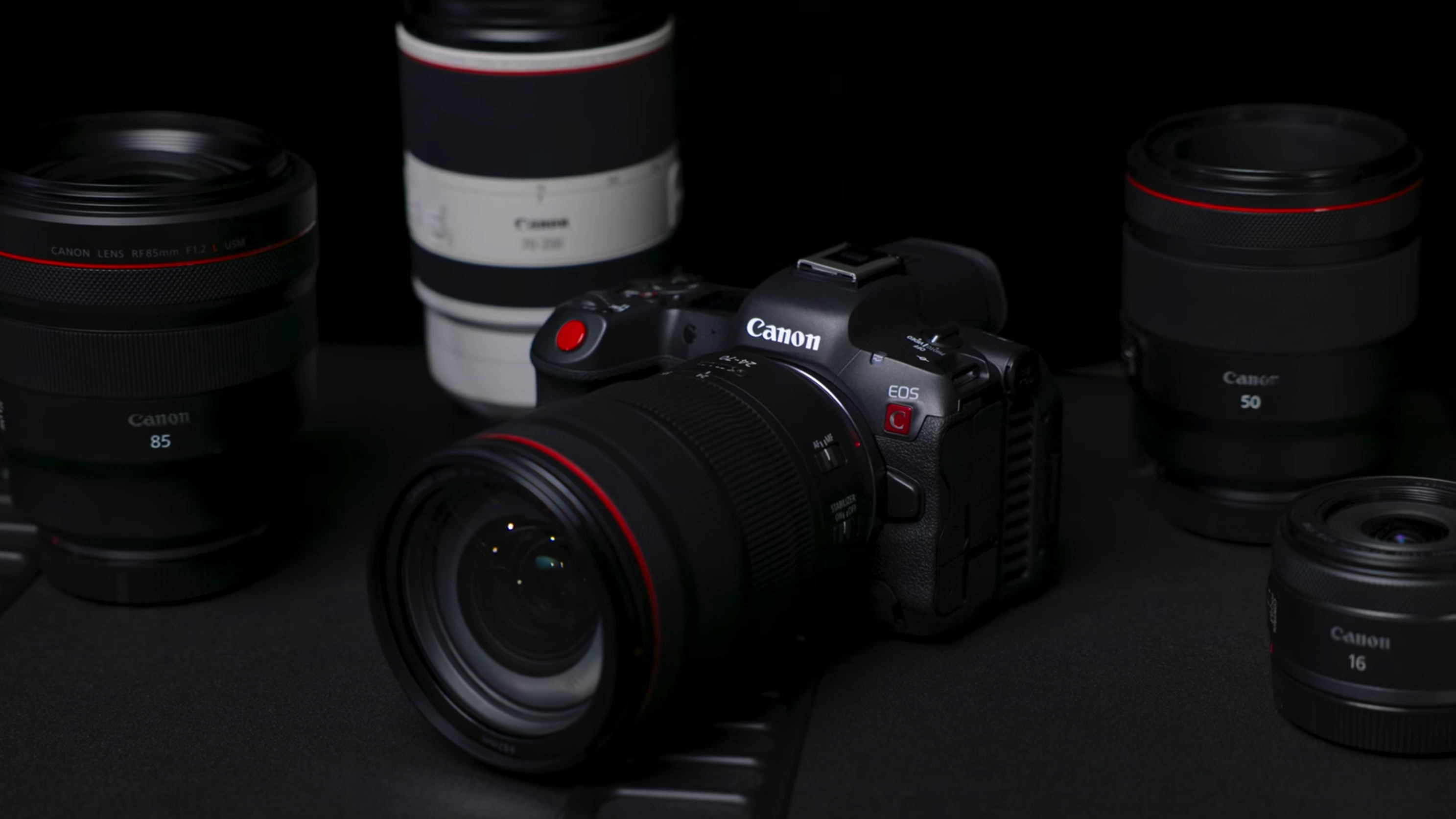 The Canon EOS R5 C camera surrounded by lenses
