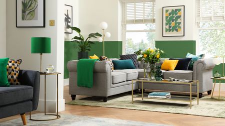 living room with grey sofa, green and white walls and grey rug 