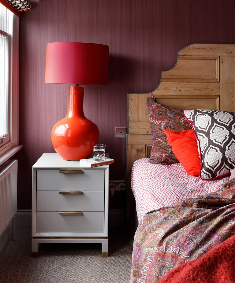 Red kids bedroom with textured wallpaper and red lamp