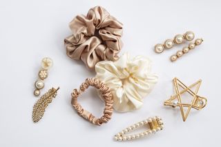 A variety of gold, cream and rose gold hair accessories including hair clips and scrunchies.
