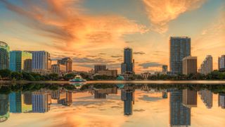 A colorful sunset over Lake Eola and Orlando, Florida with reflections captured off the lake