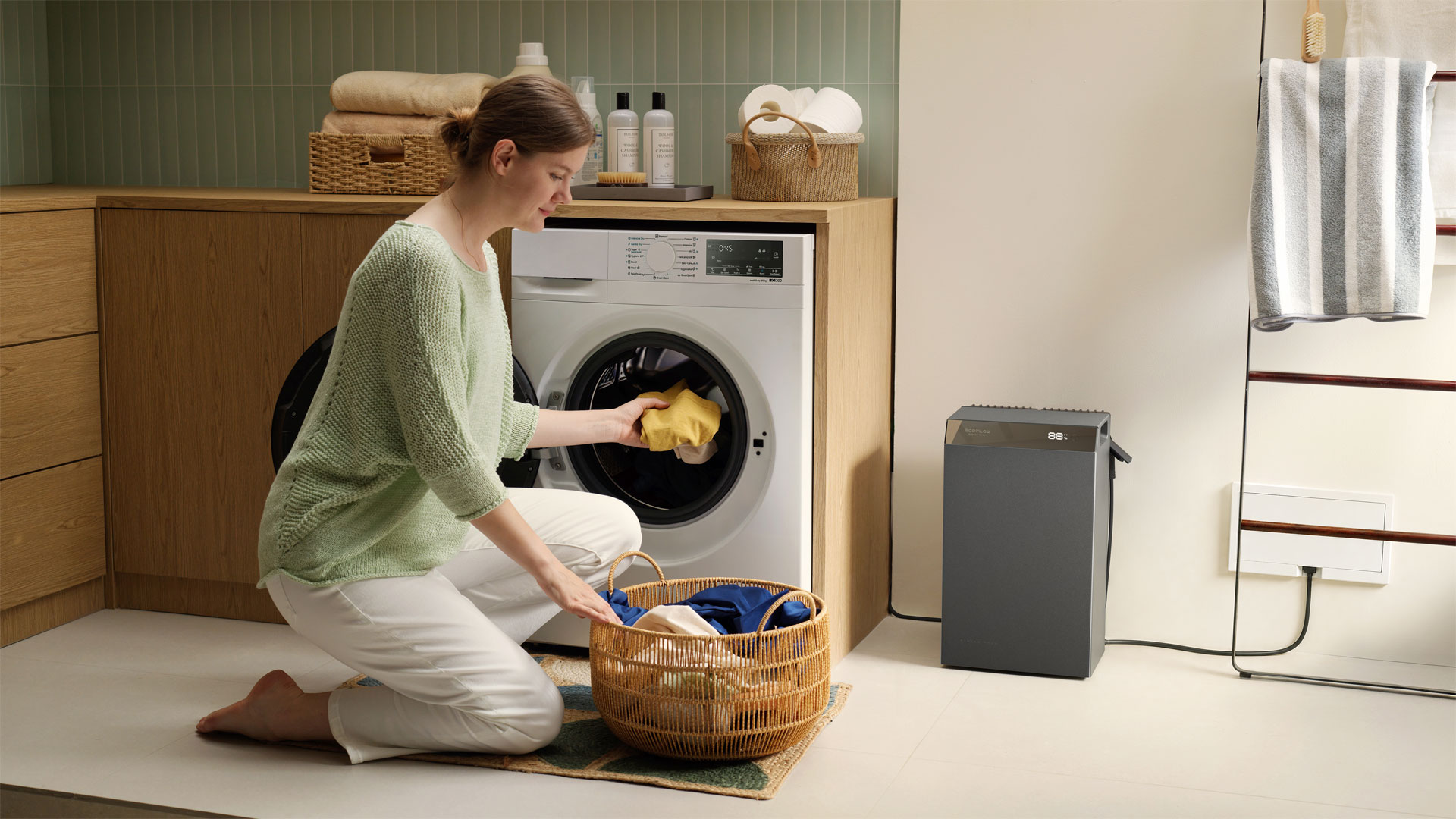A woman loading washing into a washing machine powered by the EcoFlow STREAM 5000 solar battery system