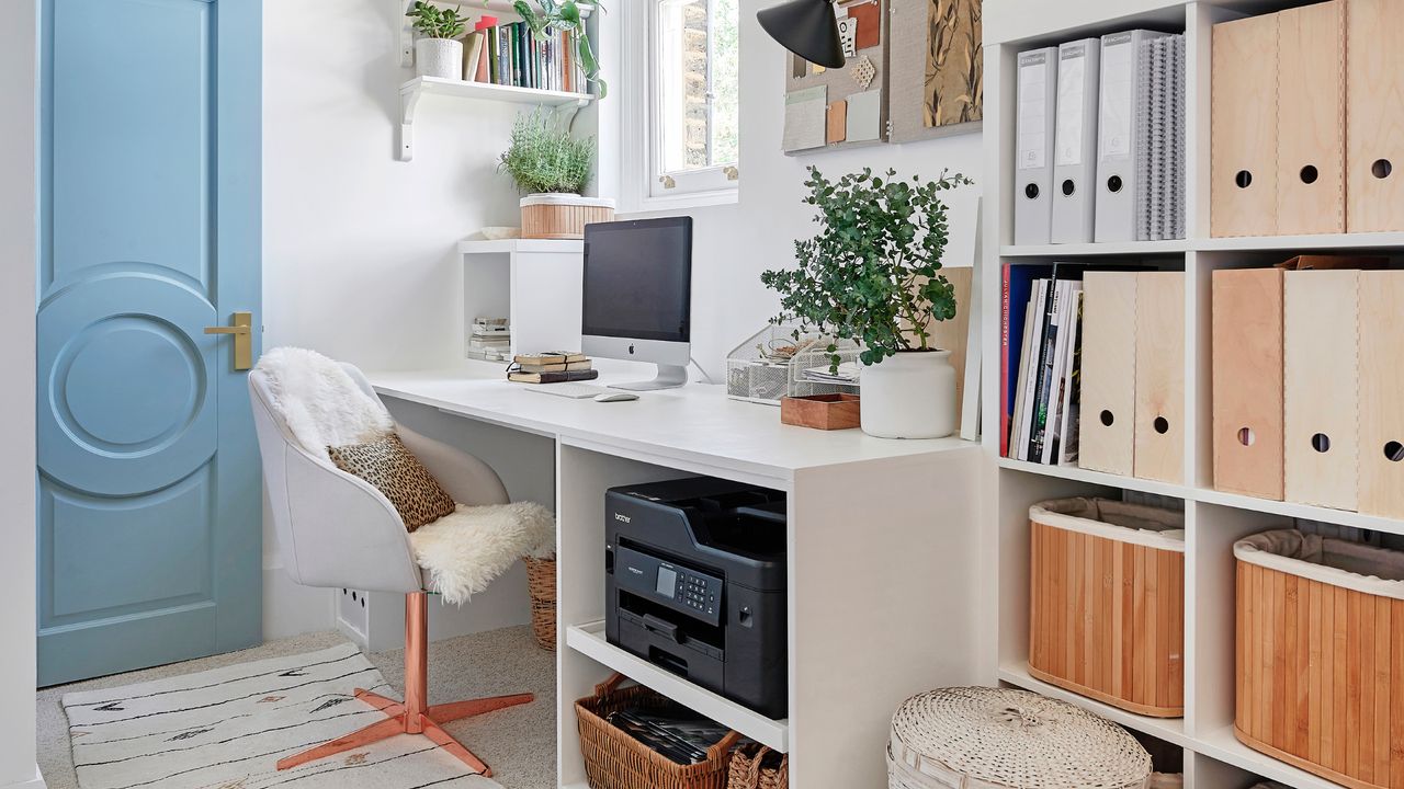 modern home office ideas, home office with white desk, white open shelving, pale blue painted door, rug, swivel chair, pinboard, baskets, open shelving 