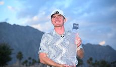 Nick Dunlap holds The American Express trophy on the 18th green