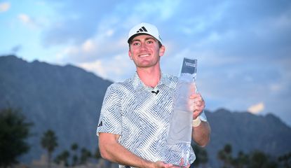 Nick Dunlap holds The American Express trophy on the 18th green