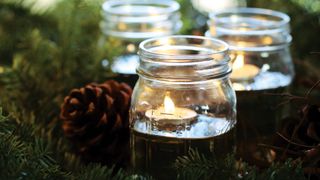 picture of mason jars with water and tealights in them