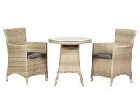 A rattan bistro set with two armchair style padded seats and a glass-topped table