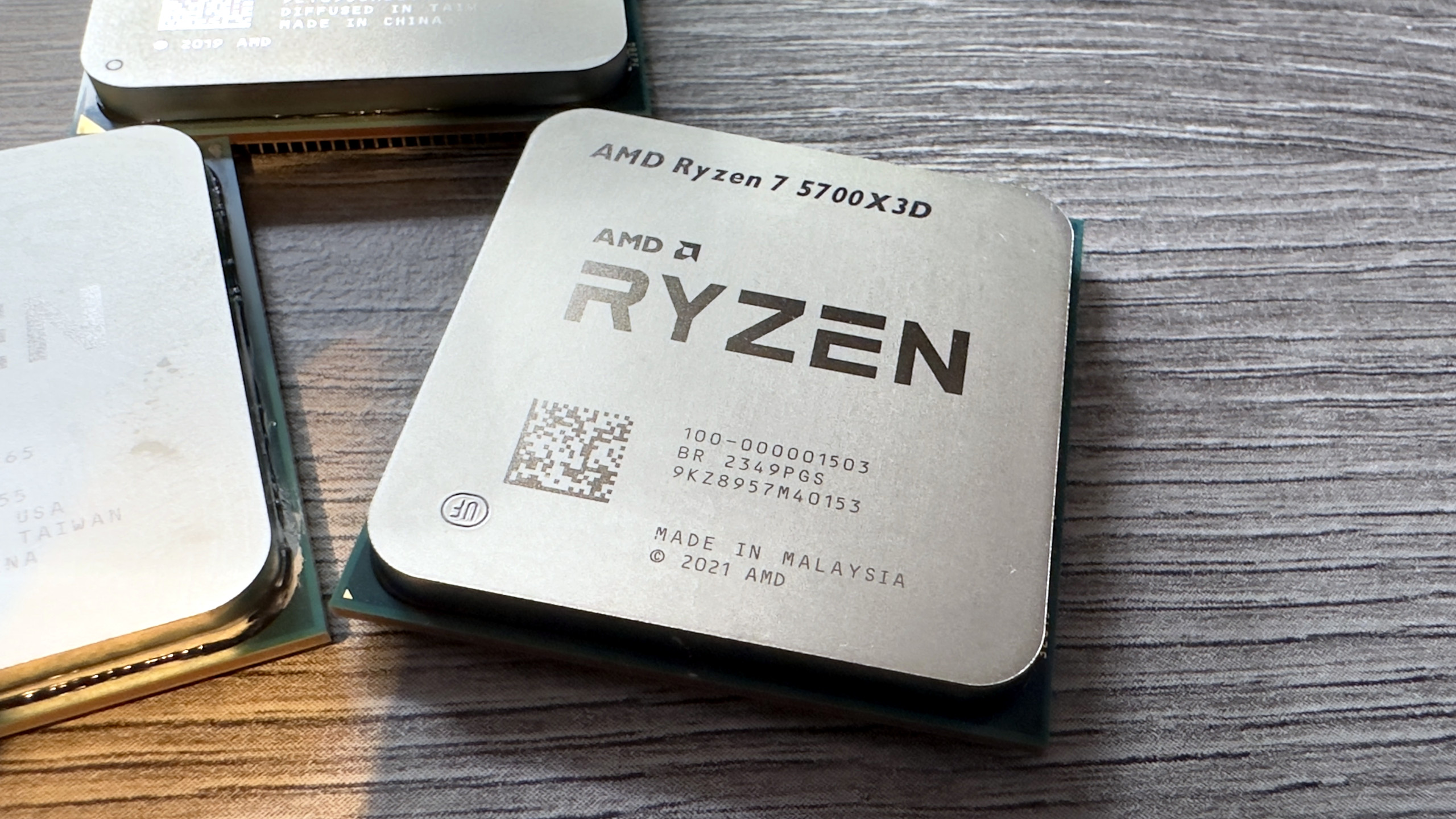 A photo of an AMD Ryzen 7 5700X3D processor resting on a desk