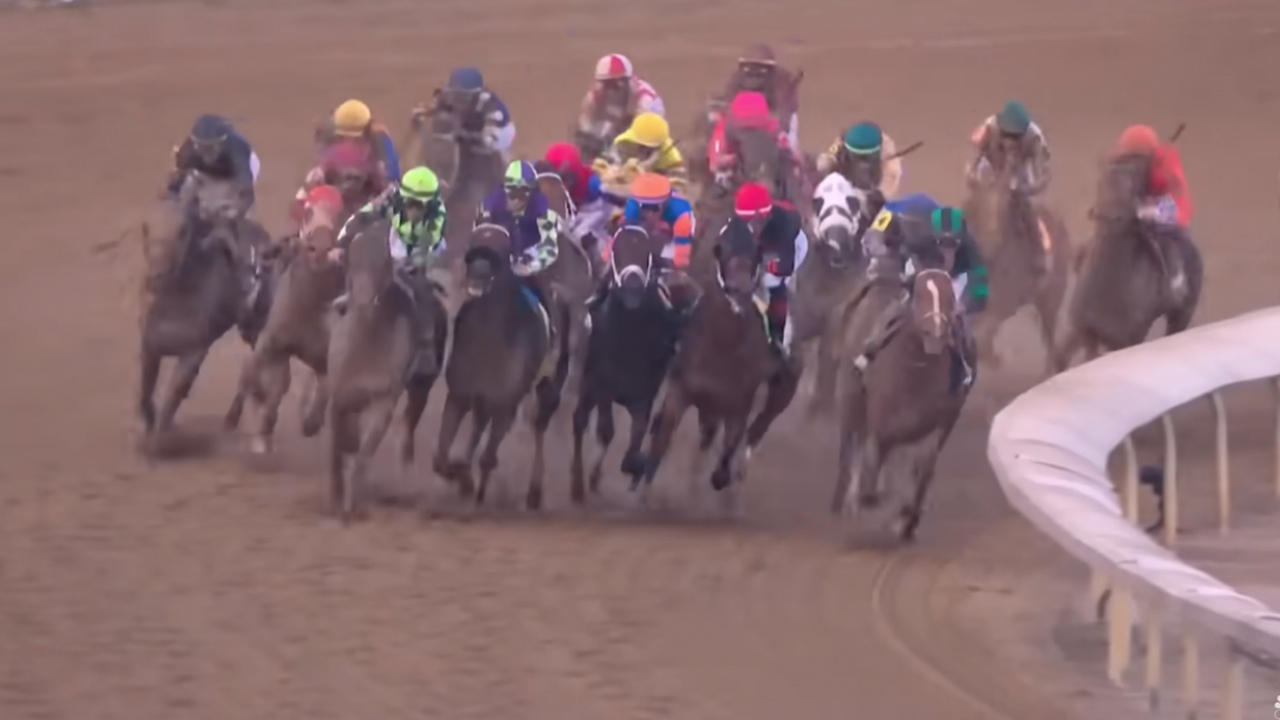 Horses coming around a corner in the Kentucky Derby