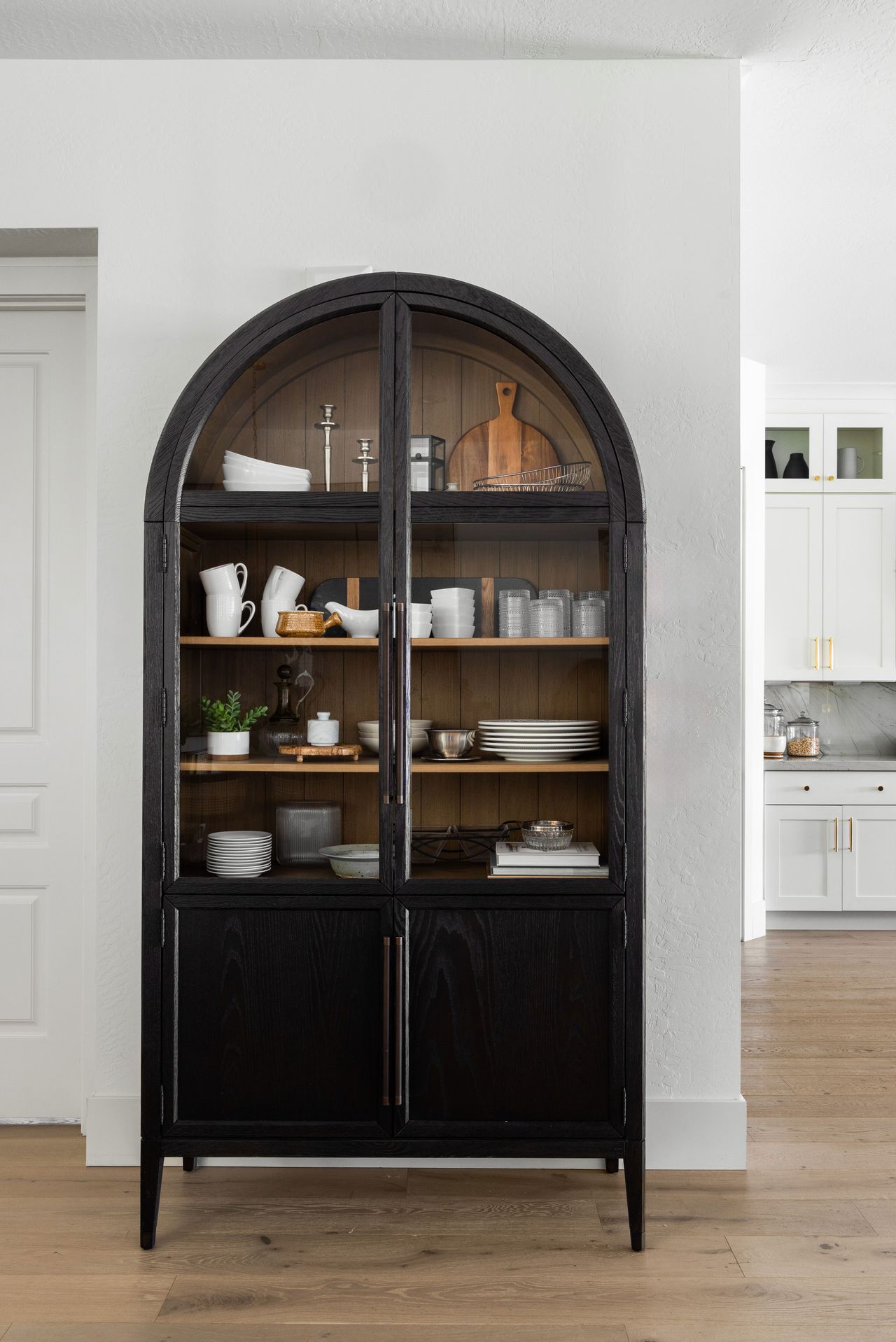 an arched cabinet for plates and cups