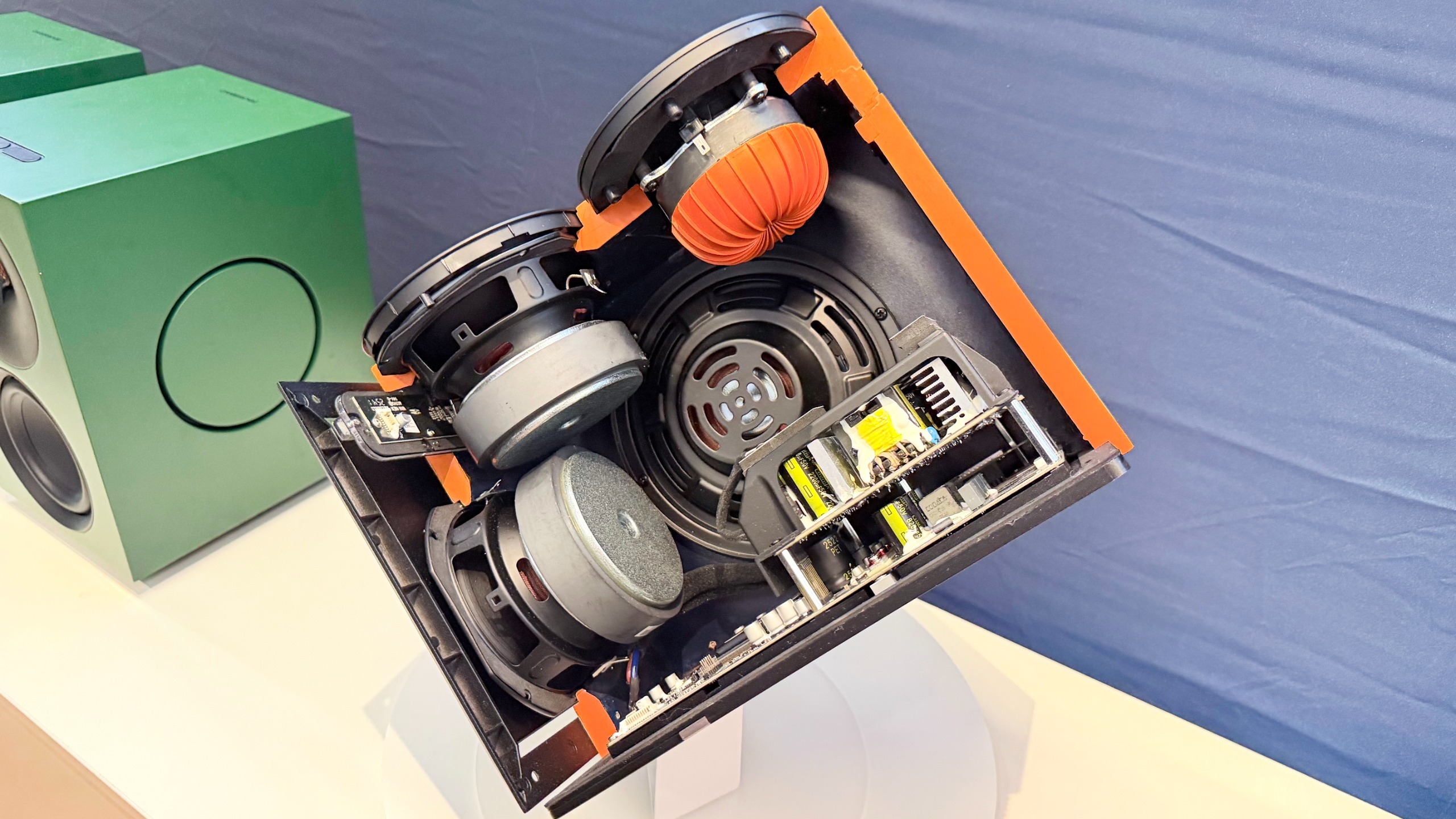 A cutaway model of the Cambridge Audio L/R X speakers, showing the inside speaker assembly with the second downfiring woofer.