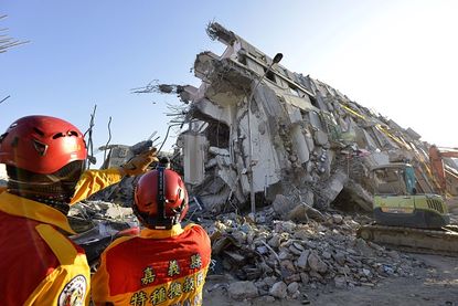 Rescuers look at the rubble of an apartment building in Taiwan.