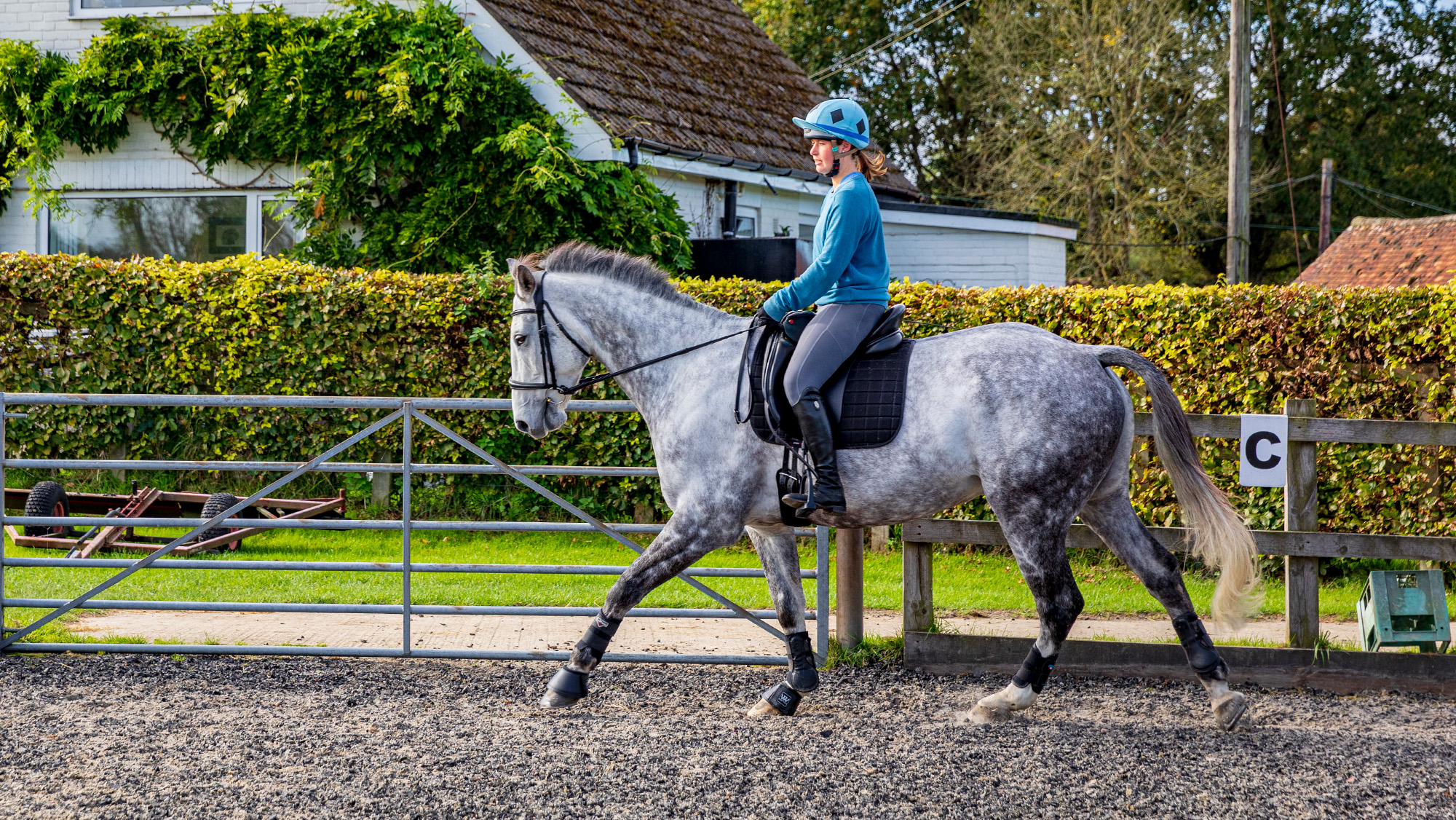 Rider cantering in arena just past a marker