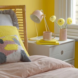 bedroom with yellow wall and bed and bedside lamp
