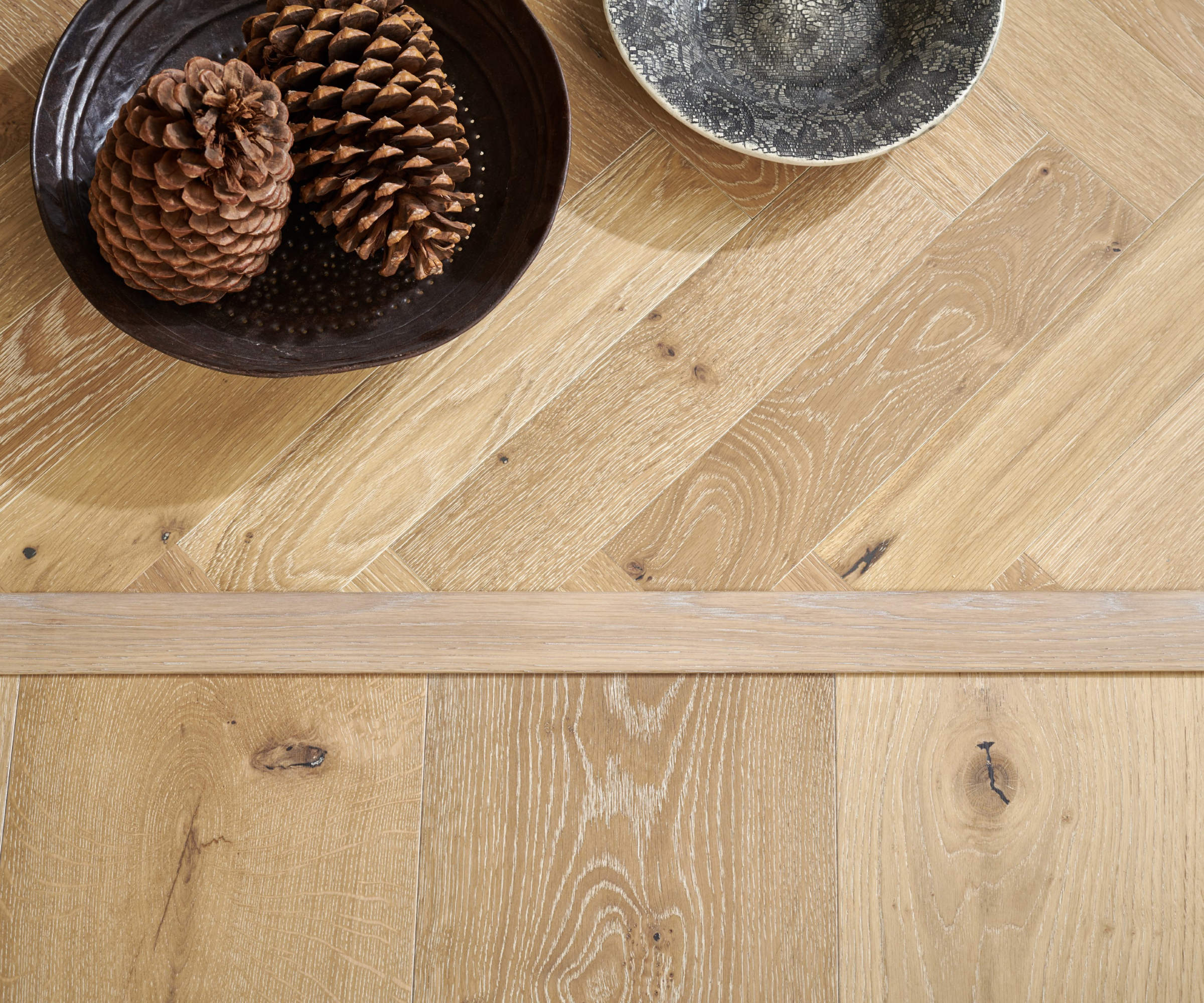 wooden floor with wooden transition strip between flooring laid in two different directions
