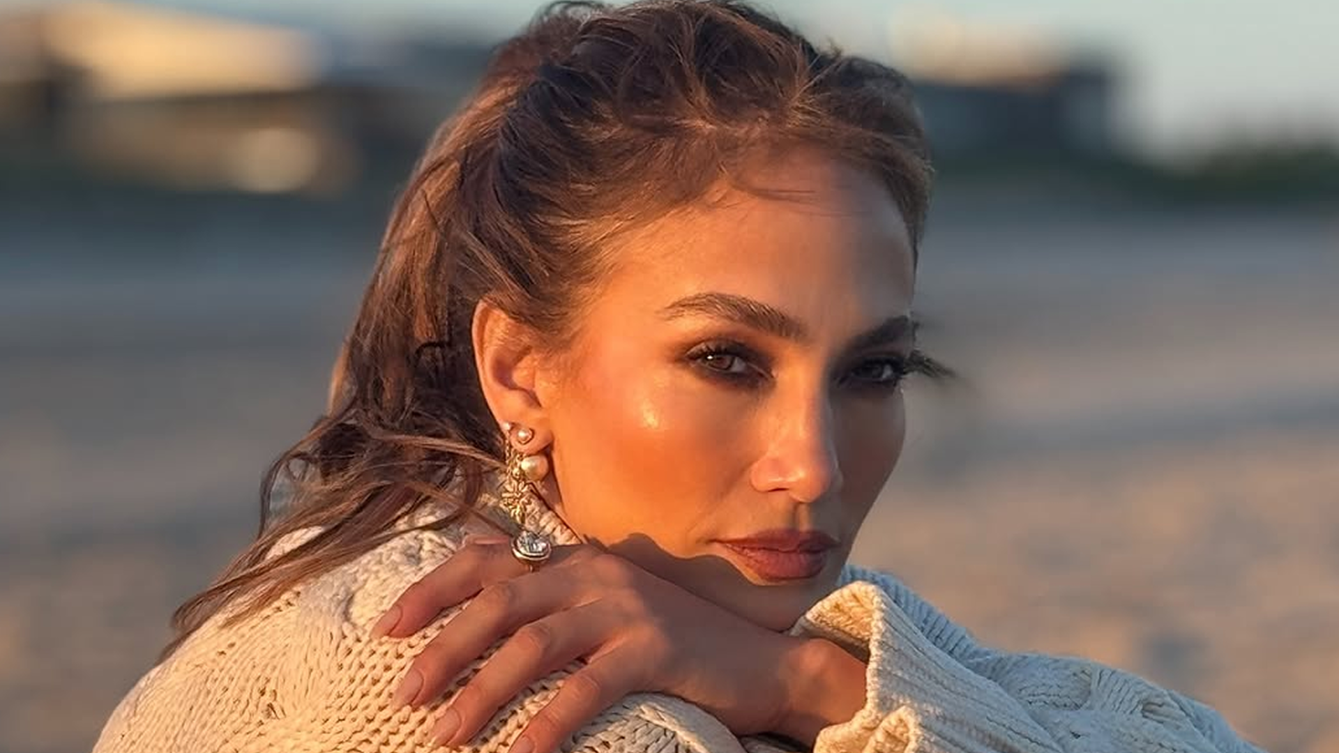 Jennifer Lopez posted on Instagram in a cardigan, lace bloomers/skirt, and lace-up knee-high boots