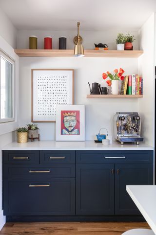 A modern kitchen with dark blue cabinetry and open shelving