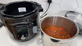 The Instant Pot Pro Crisp next to a pot of slow cooked chilli which it wa sused to prepare