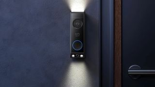 blue wall and front door with black eufy video doorbell on wall to side, with light shining out from the top and bottom of the doorbell