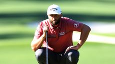 Jon Rahm ooks over a putt on the tenth green during the Masters.