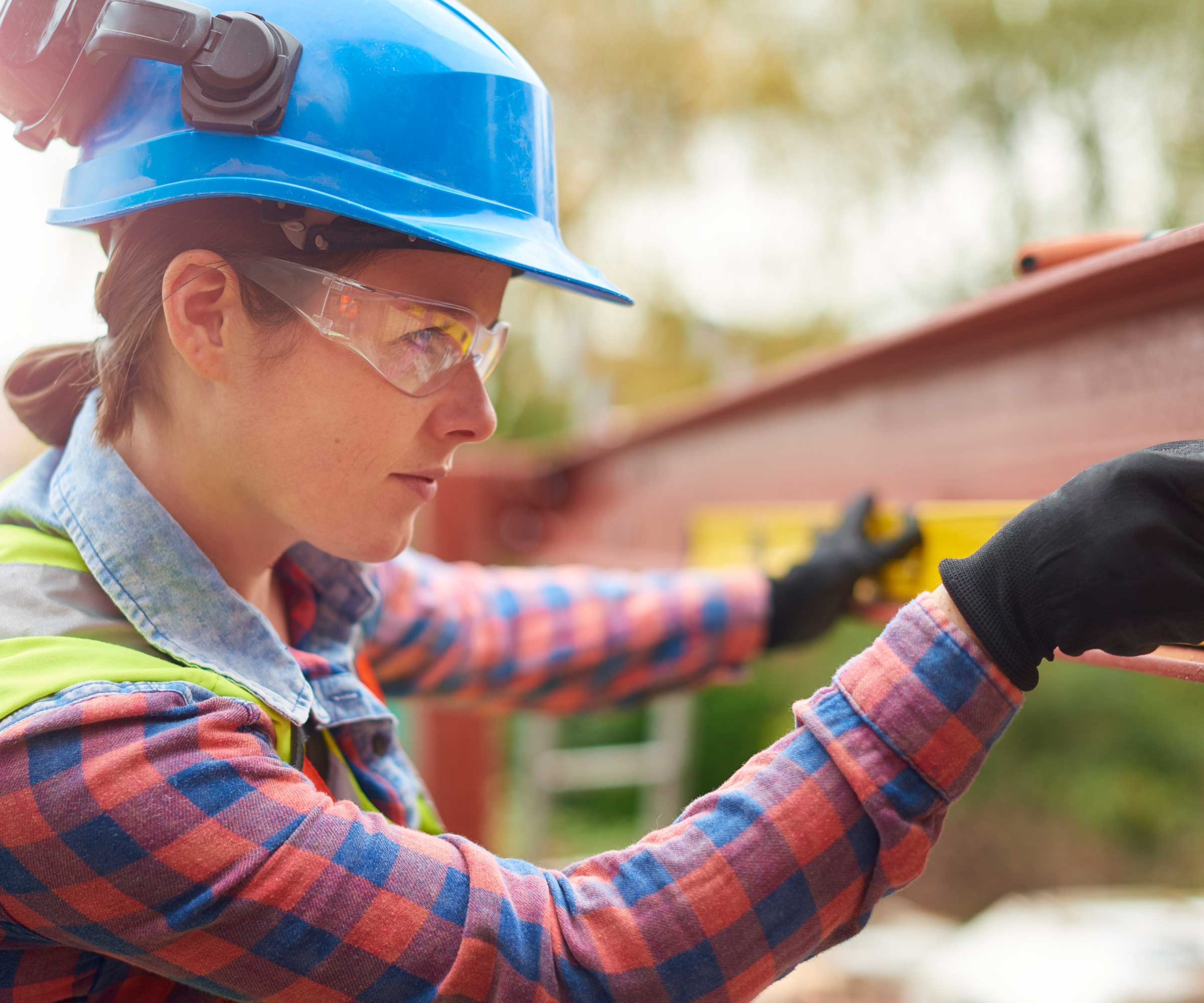 female structural engineer checking steel beam with spirit level