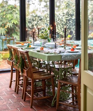 dining table with vintage chairs in a conservatory space laid for entertaining