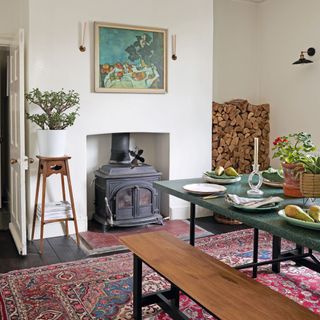 Dining room with vintage carpet, woodburner fireplace, logs, dining table