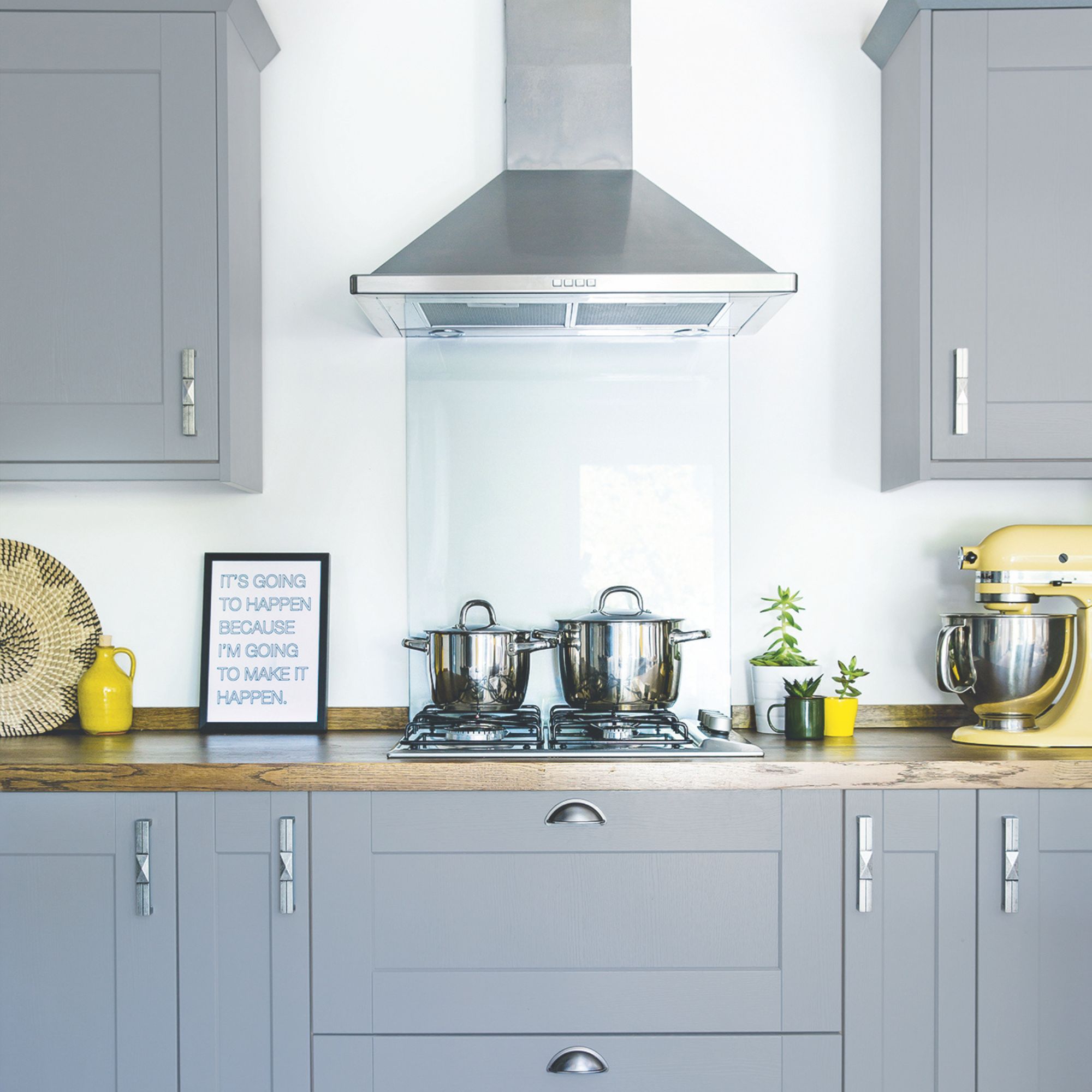 Kitchen hob area with grey cabinets above and below, and pots sitting on the hob