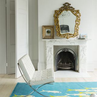 room with antique mirror blue rug and white walls