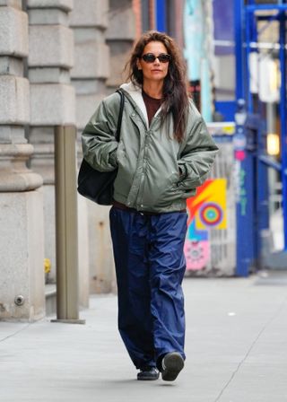 Katie Holmes wearing a shearling lined bomber jacket, wide-leg jeans a,d adidas sambas