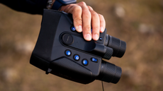 Yashica Night Vision 4K binoculars in the hand and buttons illuminated