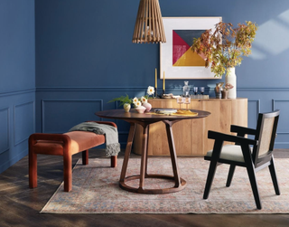 round wood dining table in a blue dining room