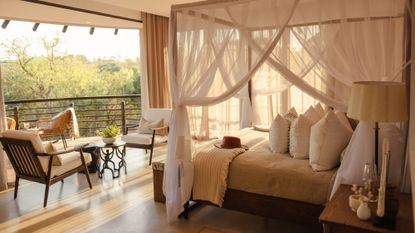 A canopy bed covered in gauzy white fabric at the Royal Thanda Club in South Africa