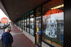 A person looks in the windows of Shake-A-Paw, a pet store in Hicksville, New York